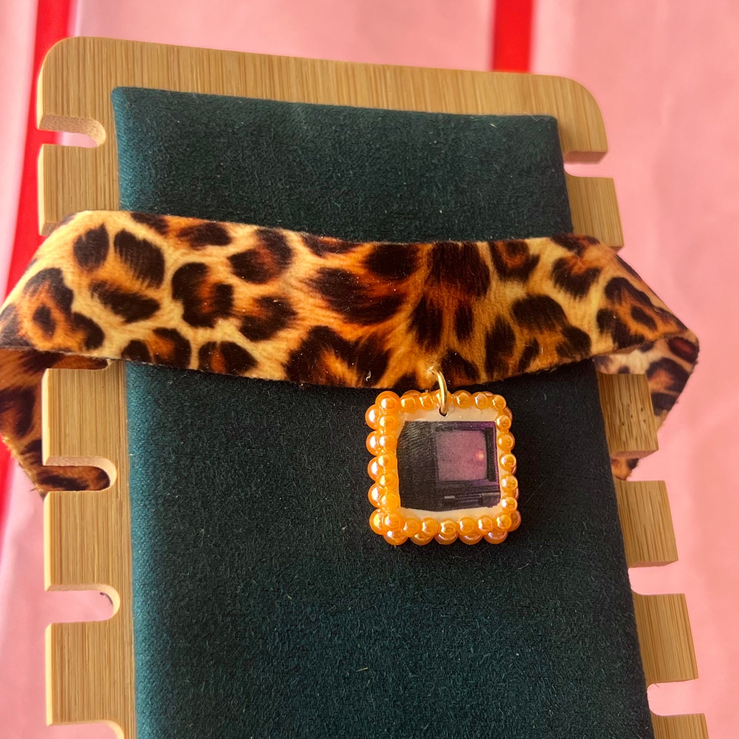 Cheetah print TV charm choker — soft cheetah print choker with handmade polymer clay retro Y2K television charm framed by bright orange pearls. Adjustable fit ~14–16" with extension chain. Gift-ready green Victorian-patterned box + bow. Wearable nostalgia kitsch jewelry; ready to ship in 1–3 days.