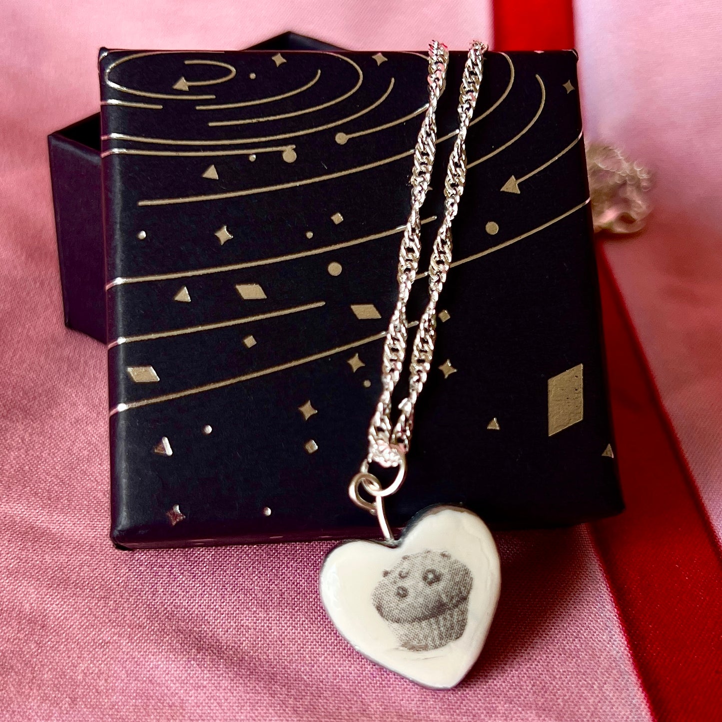 Muffin Man’s Heart blueberry muffin necklace — handmade monochrome polymer clay blueberry muffin charm with metallic silver-black finish on 20" 925 sterling silver chain. Bakerycore snackcore Y2K charm necklace; gift-ready black celestial box. Ships in 1–3 business days.