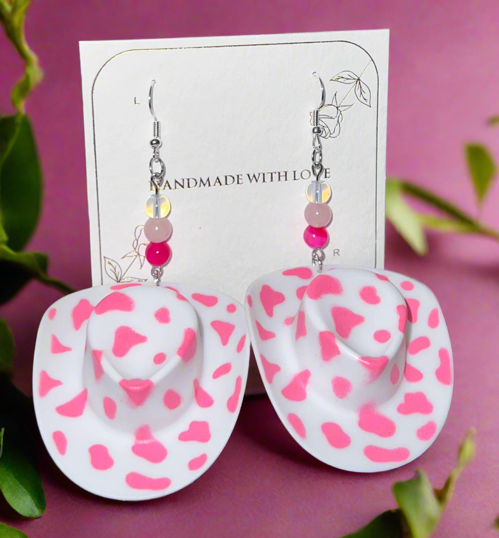 Cowboy hat-shaped earrings with pink heart patterns on a card labeled 'Handmade with Love'.