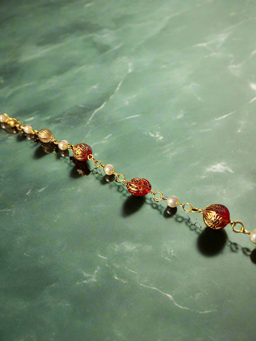 Necklace with gold and red beads on a dark background