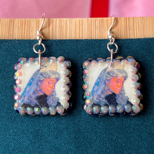Alt text: Medieval-inspired enchanted princess earrings featuring handmade polymer‑clay character charms—blonde princess with veil or brunette princess with staff—bedazzled with iridescent pearls and rhinestones, set on silver‑plated hypoallergenic hooks; perfect fantasy, princesscore, and cosplay jewelry.