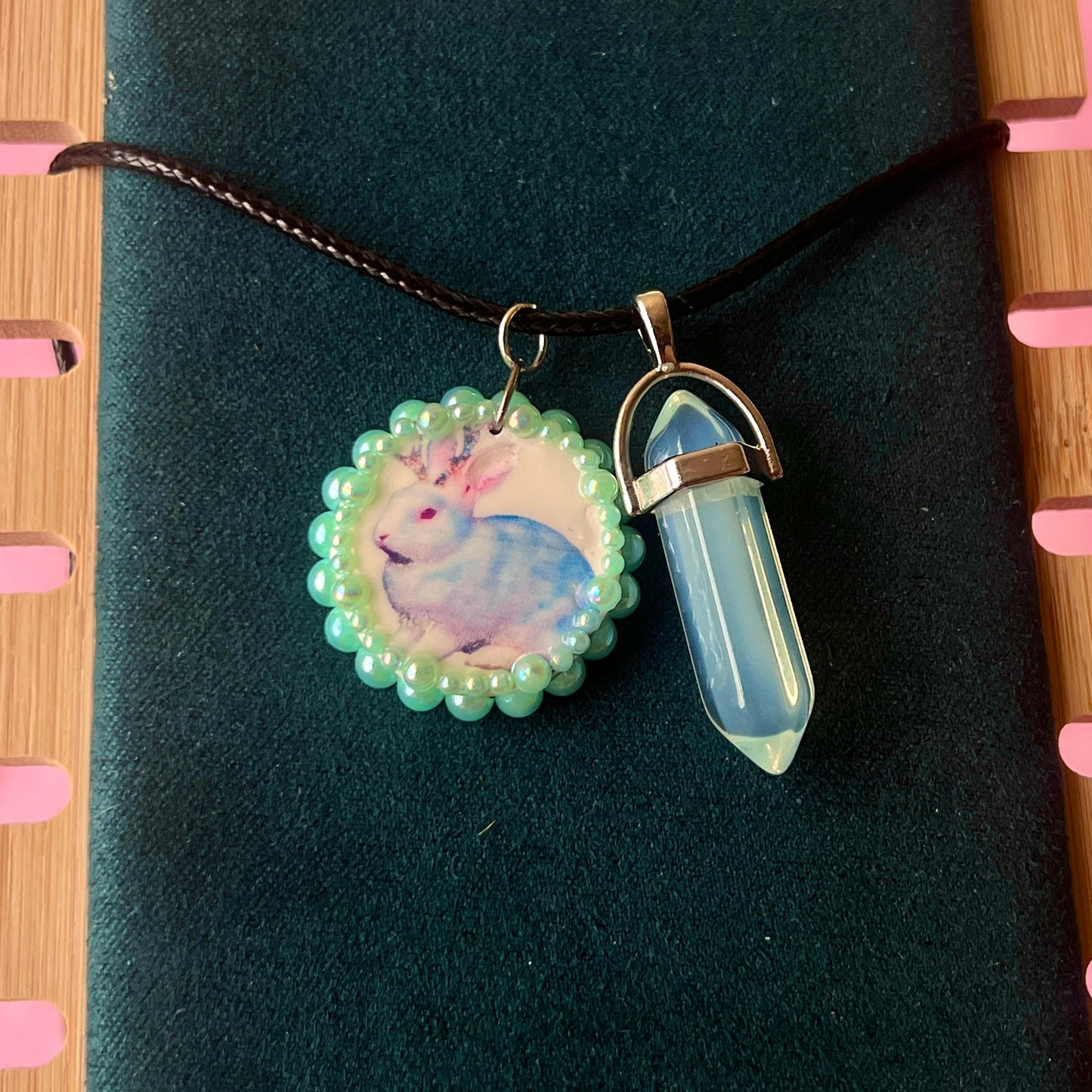 Iridescent jackalope charm necklace (Blue Magic Collection) — 22" adjustable faux leather chain with handcrafted clay jackalope charm, bedazzled and finished with iridescent pearls and iridescent back opal gem accent. Silver-plated charm findings, mixed alloy metals. Ready to ship in 1–3 days.