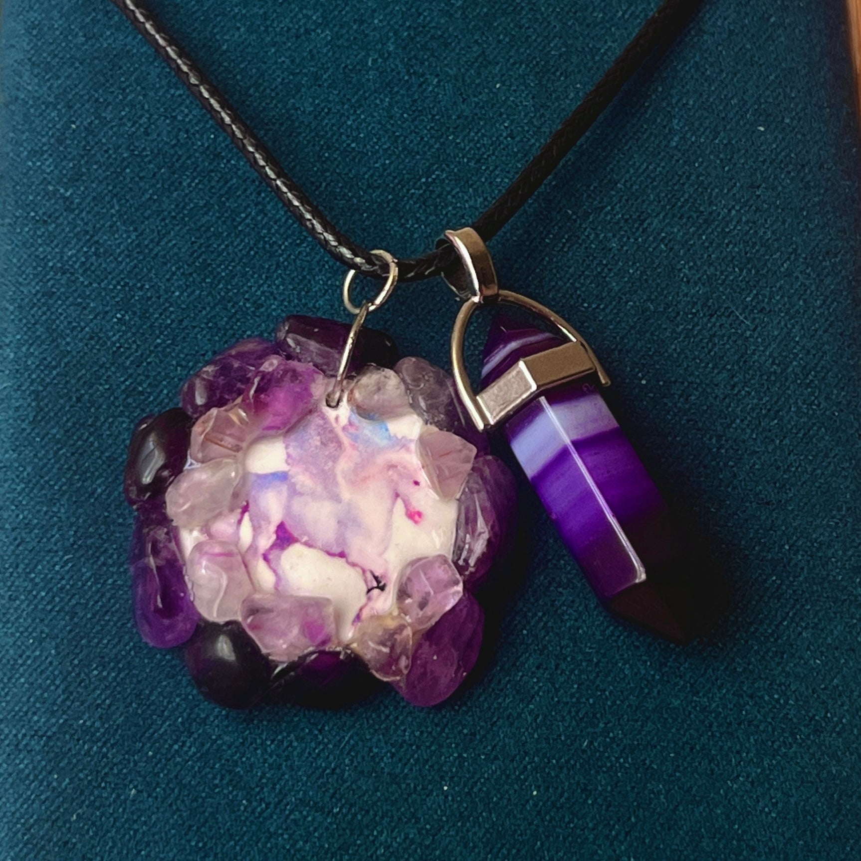 Handmade polymer clay pegasus charm necklace bedazzled with real amethyst crystals, paired with a medium statement amethyst pendant on a 22-inch black vegan leather chain.