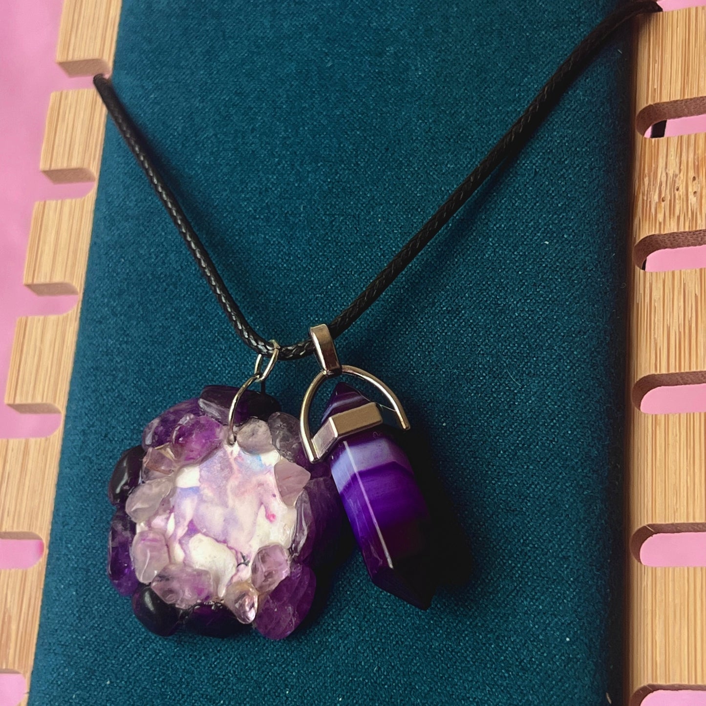 Handmade polymer clay pegasus charm necklace bedazzled with real amethyst crystals, paired with a medium statement amethyst pendant on a 22-inch black vegan leather chain.