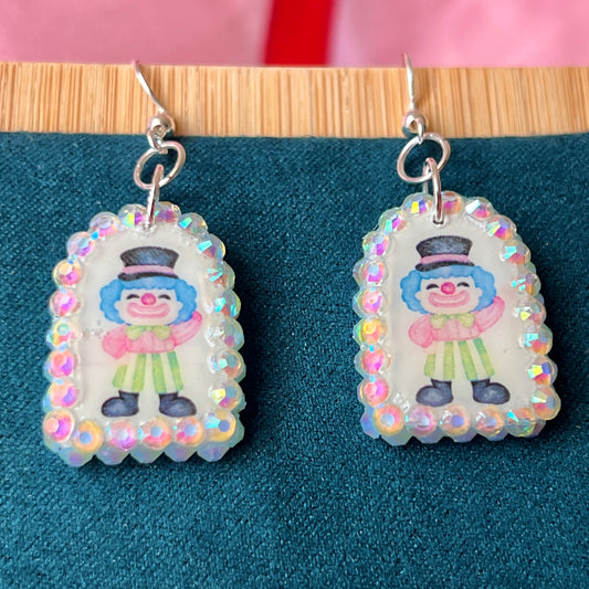 Alt text: Sparkly clown earrings—handmade polymer clay charms bedazzled with iridescent pearls and rhinestones, featuring silver‑plated hypoallergenic hooks. Perfect clowncore, kawaii, circuscore statement jewelry for festivals and alt fashion.