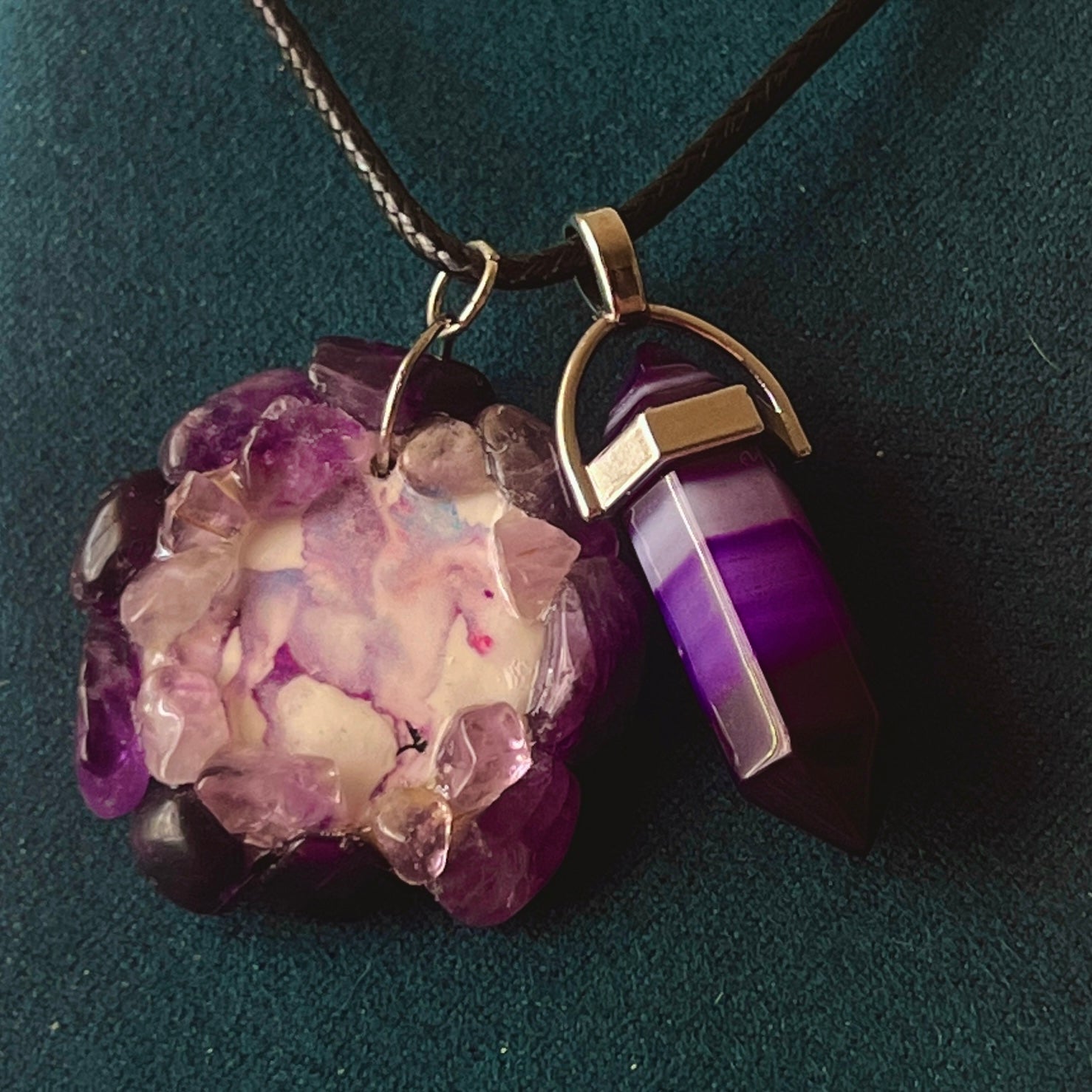 Handmade polymer clay pegasus charm necklace bedazzled with real amethyst crystals, paired with a medium statement amethyst pendant on a 22-inch black vegan leather chain.