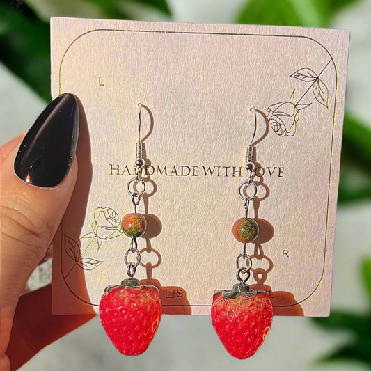 Adorable cottagecore fairy strawberry-shaped earrings with unakite gemstones on a 'Handmade with Love' card held by a hand perfect for womens fall outfits and gifts for her