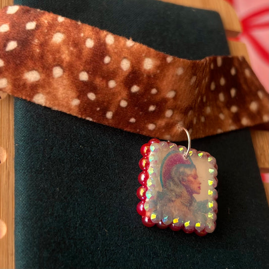 Deer print choker necklace — soft doe/deer print choker (adjustable 13–16") with handmade polymer clay elf portrait charm (approx. 1") bedazzled with iridescent red pearls + rhinestones. Gift-ready Victorian-patterned box with green bow. Fairycore coquette Y2K whimsical jewelry; ready to ship in 1–3 days.