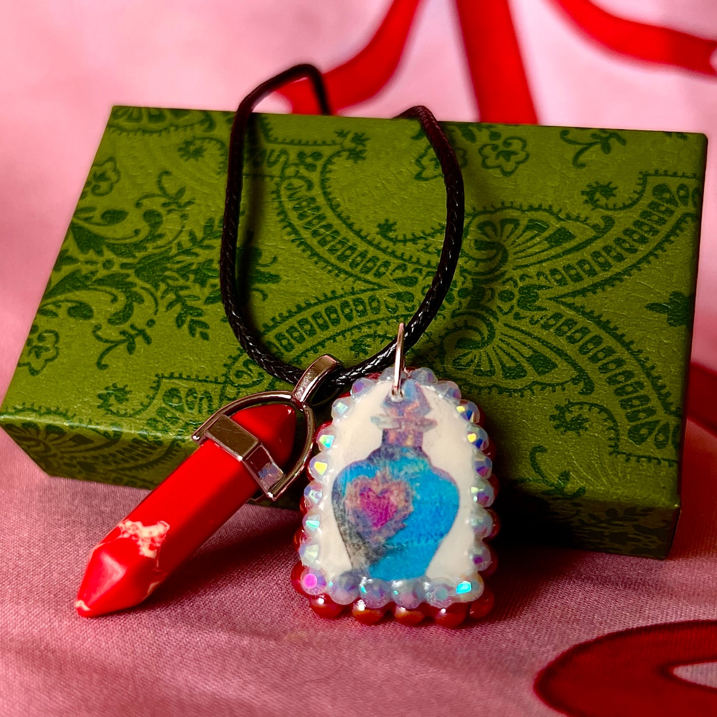 Red crystal blue potion necklace — handmade polymer clay potion bottle pendant hand-bedazzled with iridescent pearls + rhinestones and finished with vivid red crystal accent. Gift-ready Victorian-patterned box. Fairycore Y2K fantasy charm necklace; ready to ship in 1–3 days.