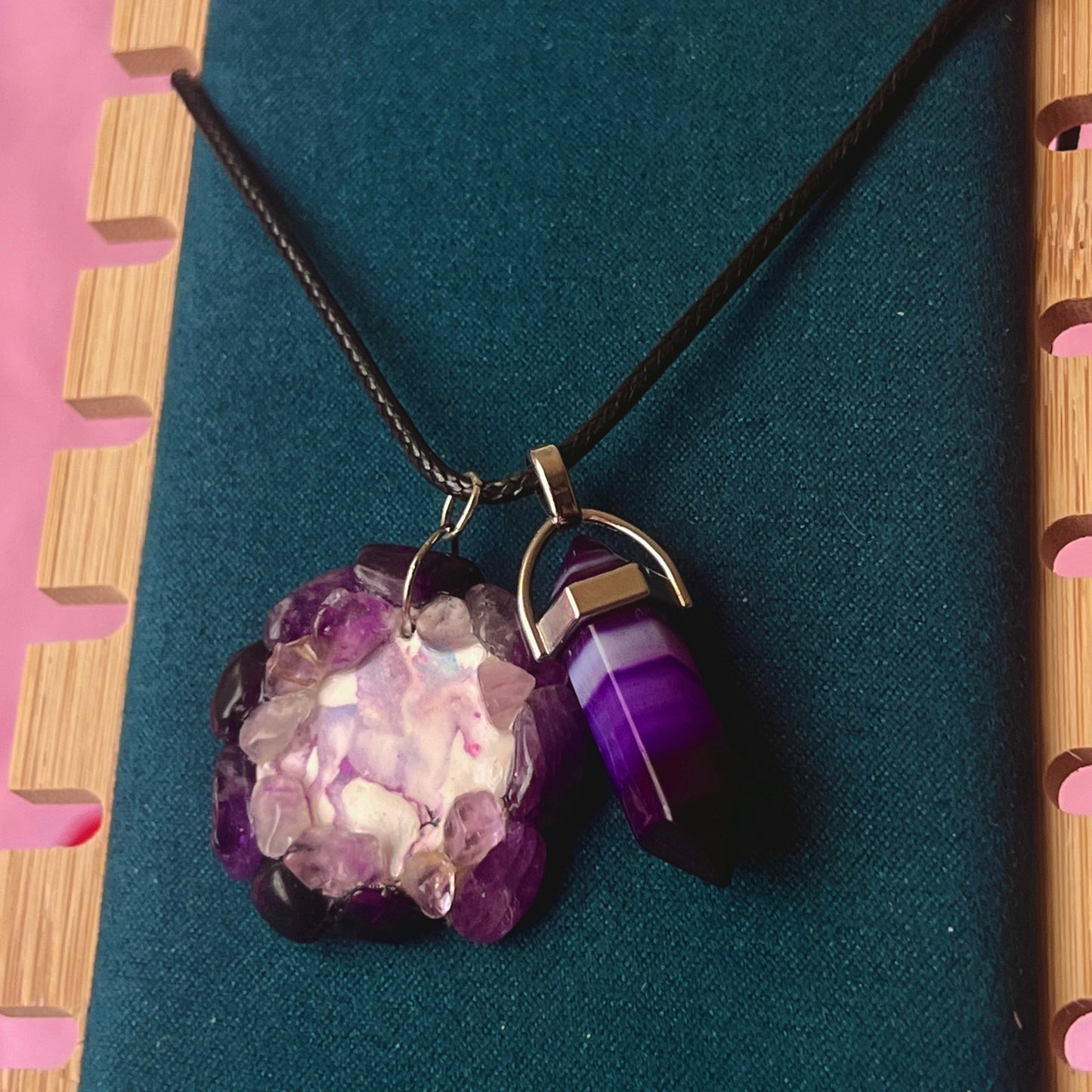 Handmade polymer clay pegasus charm necklace bedazzled with real amethyst crystals, paired with a medium statement amethyst pendant on a 22-inch black vegan leather chain.