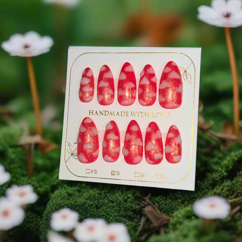 Hot pink nails with a gold shimmer sparkle topped with white fluffy clouds. The pink sky princess nails are on a card which reads "handmade with love"