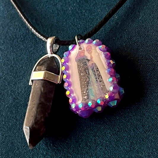 Medieval sorceress polymer charm necklace — black vegan leather chain with black marbled stone pendant plus arched sorceress charm (approx. 1" x 0.75") featuring staff + glowing orb, bedazzled with purple iridescent pearls. Dark medievalcore / fantasy talisman jewelry; ready to ship.