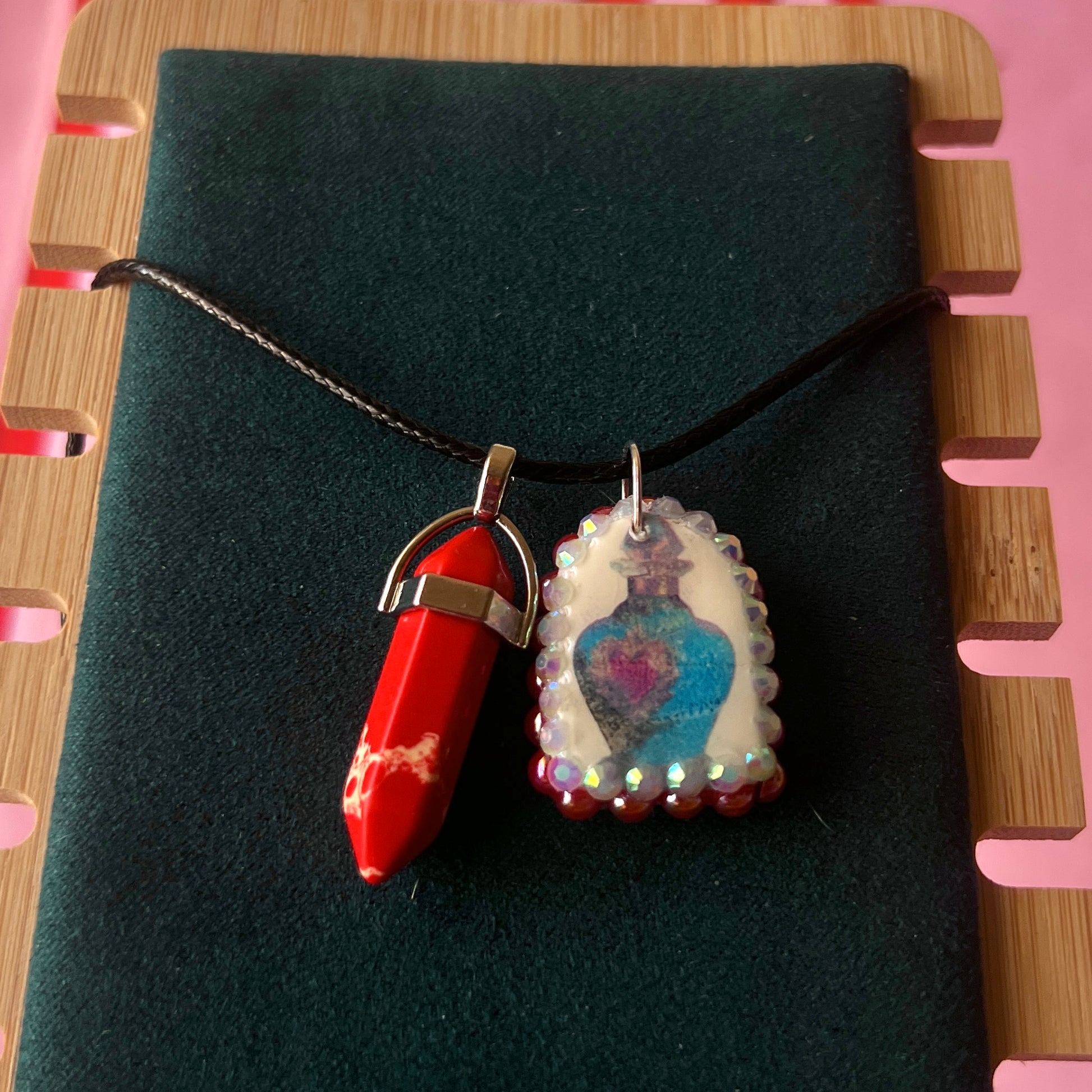 Red crystal blue potion necklace — handmade polymer clay potion bottle pendant hand-bedazzled with iridescent pearls + rhinestones and finished with vivid red crystal accent. Gift-ready Victorian-patterned box. Fairycore Y2K fantasy charm necklace; ready to ship in 1–3 days.