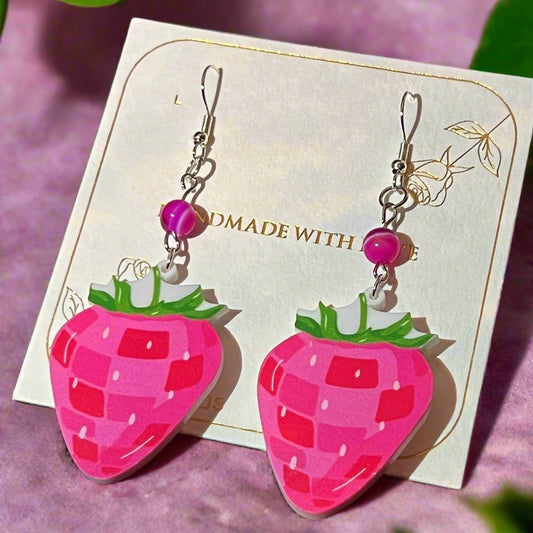 Neon pink strawberry-shaped earrings with dark pink agate crystal gemstone bead on a card with 'MADE WITH LOVE' text