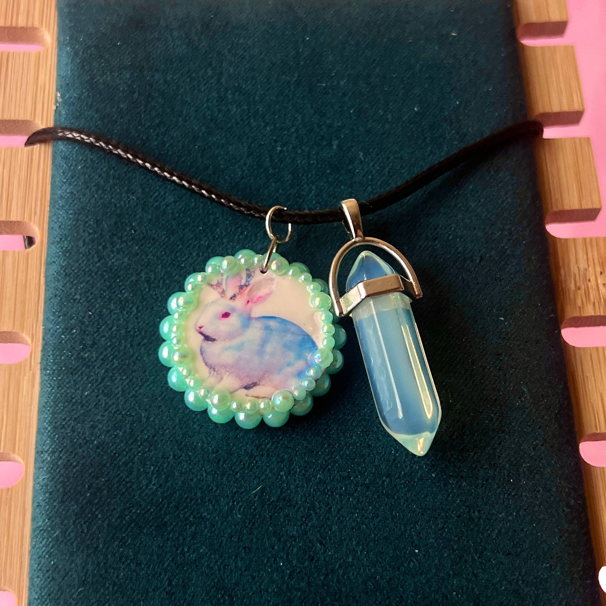 Iridescent jackalope charm necklace (Blue Magic Collection) — 22" adjustable faux leather chain with handcrafted clay jackalope charm, bedazzled and finished with iridescent pearls and iridescent back opal gem accent. Silver-plated charm findings, mixed alloy metals. Ready to ship in 1–3 days.