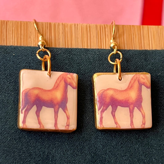 Handmade golden toy horse earrings with polymer‑clay mini horse charms painted in metallic gold, featuring gold‑plated hypoallergenic hooks—dreamcore, trinketcore, nostalgic jewelry perfect for collectors.