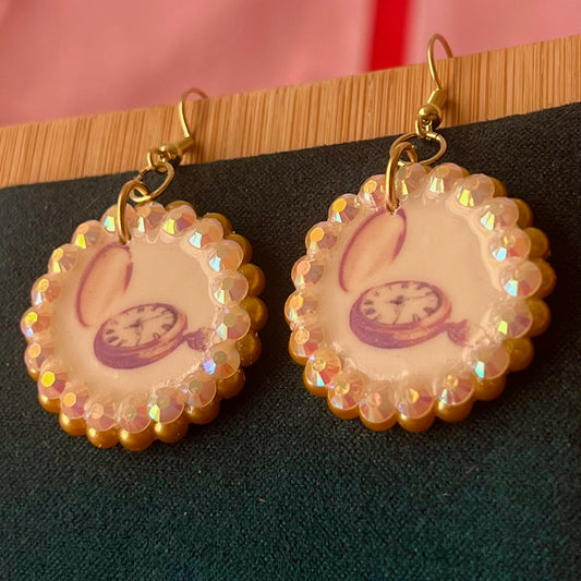 Handmade golden compass charm earrings featuring polymer‑clay image transfer, a 1‑inch circle charm framed with golden pearls and rhinestones, 18k gold‑plated hypoallergenic findings, and a balanced, luxuriously weighted feel—perfect nautical‑core, travel‑talisman, gold statement jewelry for a meaningful, sparkly look.