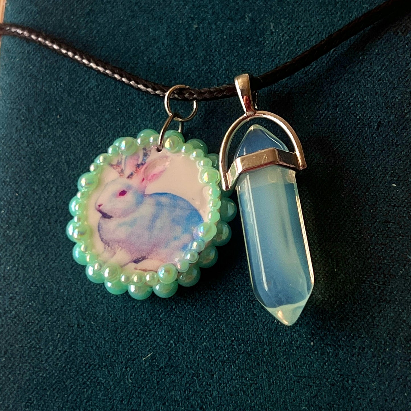 Iridescent jackalope charm necklace (Blue Magic Collection) — 22" adjustable faux leather chain with handcrafted clay jackalope charm, bedazzled and finished with iridescent pearls and iridescent back opal gem accent. Silver-plated charm findings, mixed alloy metals. Ready to ship in 1–3 days.