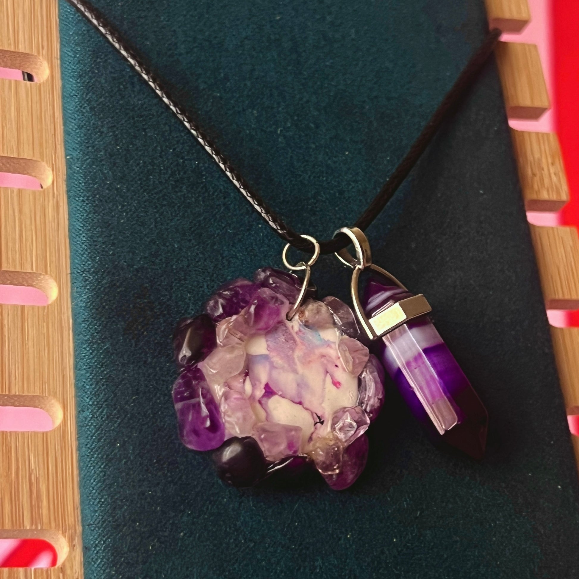 Handmade polymer clay pegasus charm necklace bedazzled with real amethyst crystals, paired with a medium statement amethyst pendant on a 22-inch black vegan leather chain.