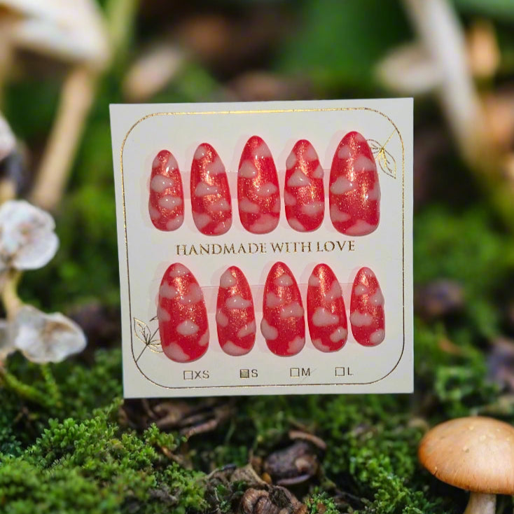 Hot pink nails with a gold shimmer sparkle topped with white fluffy clouds. The pink sky princess nails are on a card which reads "handmade with love"