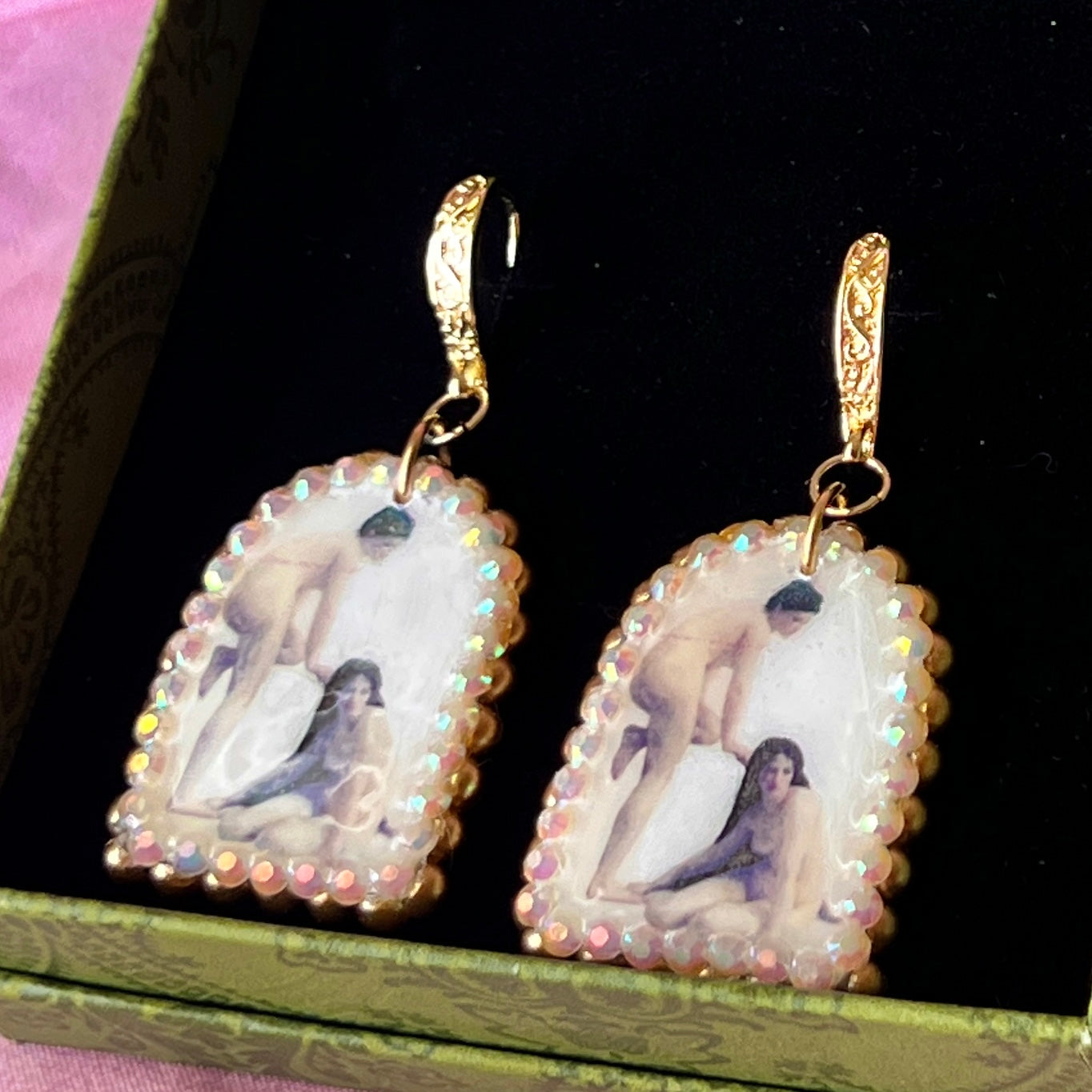 A wearable‑art pair of Bouguereau Bathers earrings — white polymer‑clay arch charms printed with “The Bathers” artwork of two nude women, one standing and one seated on the ground, embellished with gold pearls and clear rhinestones, on 18k gold‑plated hooks; perfect museum‑core, renaissance‑core, coquette statement earrings for art lovers.
