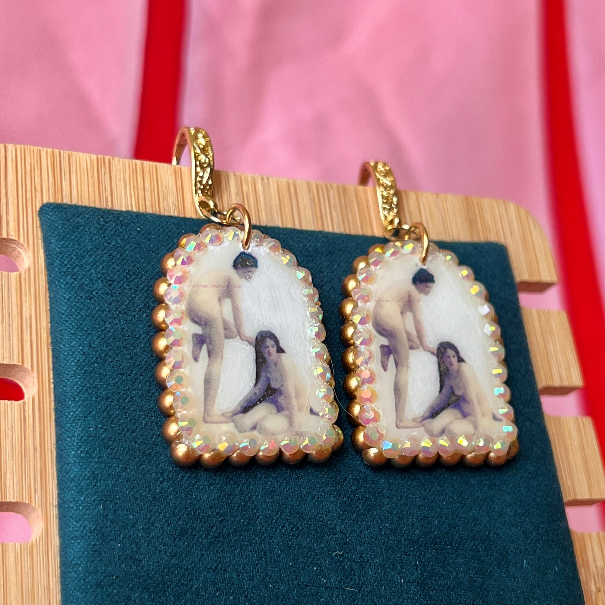 A wearable‑art pair of Bouguereau Bathers earrings — white polymer‑clay arch charms printed with “The Bathers” artwork, embellished with gold pearls and clear rhinestones, on 18k gold‑plated hooks; perfect museum‑core, renaissance‑core, coquette statement earrings for art lovers.