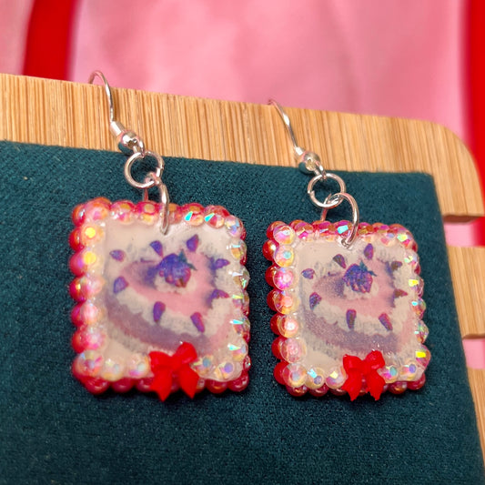 Handmade strawberry cake and bow earrings — polymer‑clay charm, iridescent pearls, rhinestones, silver‑plated hypoallergenic hooks; sweet coquette, kawaii, pastel, Y2K dessert jewelry.