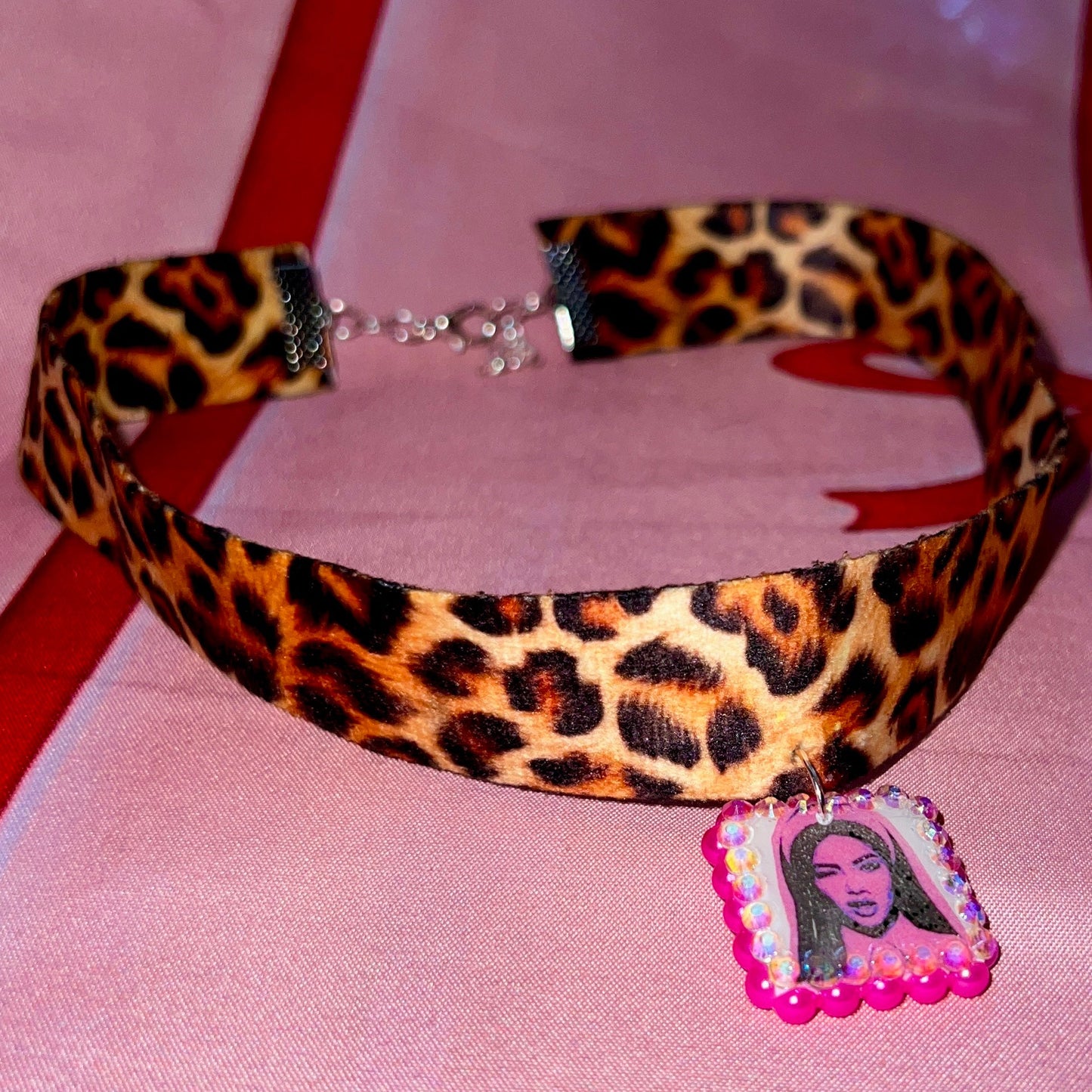Cheetah print choker necklace — 16" soft fabric cheetah print choker with neon hot pink Y2K nun charm handmade in polymer clay and bedazzled with iridescent beads. Gift-ready green Victorian-patterned box. Whimsigoth grunge indie statement choker; ready to ship in 1–3 business days.