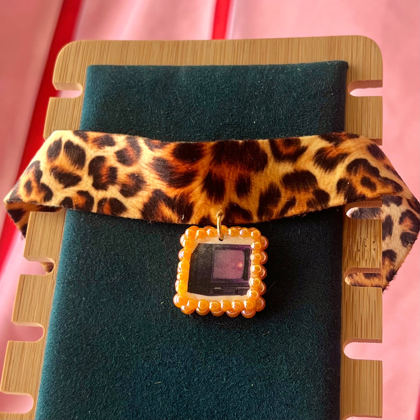 Cheetah print TV charm choker — soft cheetah print choker with handmade polymer clay retro Y2K television charm framed by bright orange pearls. Adjustable fit ~14–16" with extension chain. Gift-ready green Victorian-patterned box + bow. Wearable nostalgia kitsch jewelry; ready to ship in 1–3 days.