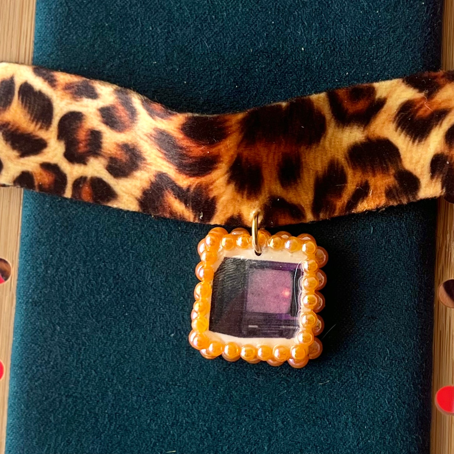 Cheetah print TV charm choker — soft cheetah print choker with handmade polymer clay retro Y2K television charm framed by bright orange pearls. Adjustable fit ~14–16" with extension chain. Gift-ready green Victorian-patterned box + bow. Wearable nostalgia kitsch jewelry; ready to ship in 1–3 days.
