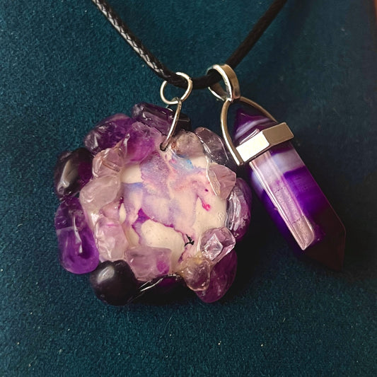 Handmade polymer clay pegasus charm necklace bedazzled with real amethyst crystals, paired with a medium statement amethyst pendant on a 22-inch black vegan leather chain.