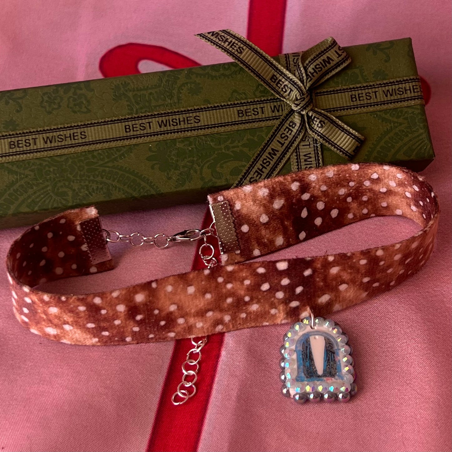 Deer print choker necklace — soft doe/deer print choker (adjustable 13–16") with handmade polymer clay liminal cloaked magic archway charm (approx. 1") bedazzled with iridescent pearls + rhinestones. Gift-ready Victorian-patterned box with green bow. Ready to ship in 1–3 days.