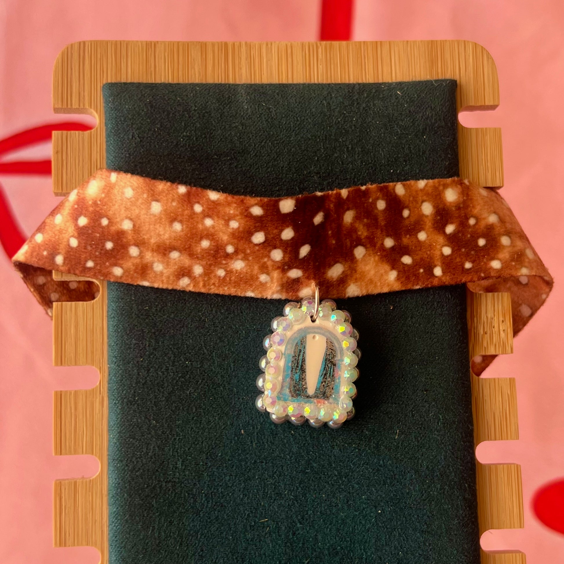 Deer print choker necklace — soft doe/deer print choker (adjustable 13–16") with handmade polymer clay liminal cloaked magic archway charm (approx. 1") bedazzled with iridescent pearls + rhinestones. Gift-ready Victorian-patterned box with green bow. Ready to ship in 1–3 days.
