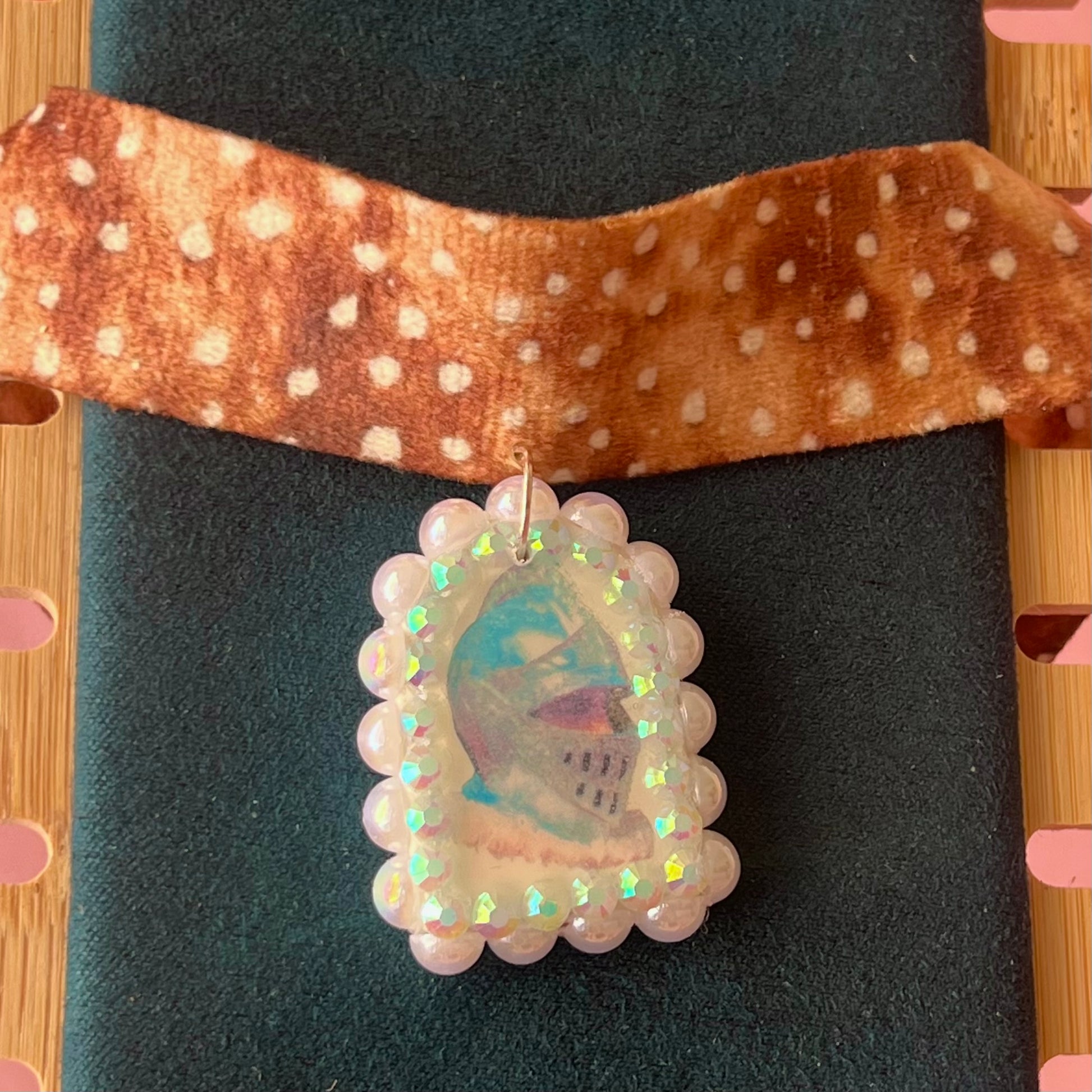 Deer print choker necklace with a handmade polymer clay iridescent medieval knight charm (about 1.75 inches), embellished with white pearls and rhinestones, shown in a Victorian patterned gift box with a green bow.