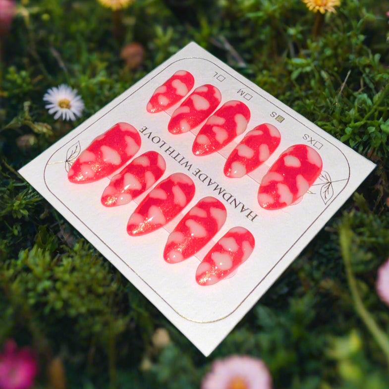 Hot pink nails with a gold shimmer sparkle topped with white fluffy clouds. The pink sky princess nails are on a card which reads "handmade with love"