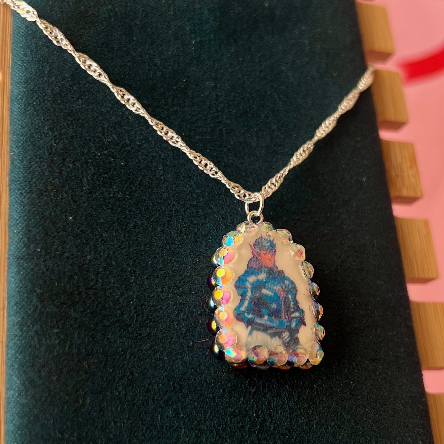 Elf Knight Necklace by Olive Made — a handmade polymer clay fantasy charm necklace featuring a medieval-inspired elf in knight armor, embellished with iridescent pearls and sparkling rhinestones. This whimsical medievalcore / fairycore statement piece comes on a 20” 925 sterling silver chain and arrives gift-ready in a Victorian patterned box with a green bow. Perfect for renaissance fair outfits, elfcore styling, and storybook gifting. Ready to ship in 1–3 business days.