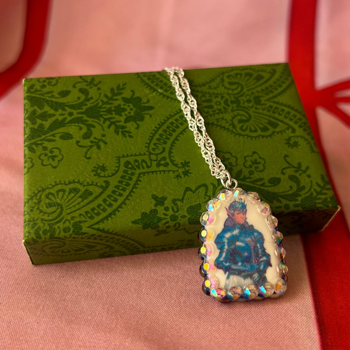 Elf Knight Necklace by Olive Made — a handmade polymer clay fantasy charm necklace featuring a medieval-inspired elf in knight armor, embellished with iridescent pearls and sparkling rhinestones. This whimsical medievalcore / fairycore statement piece comes on a 20” 925 sterling silver chain and arrives gift-ready in a Victorian patterned box with a green bow. Perfect for renaissance fair outfits, elfcore styling, and storybook gifting. Ready to ship in 1–3 business days.