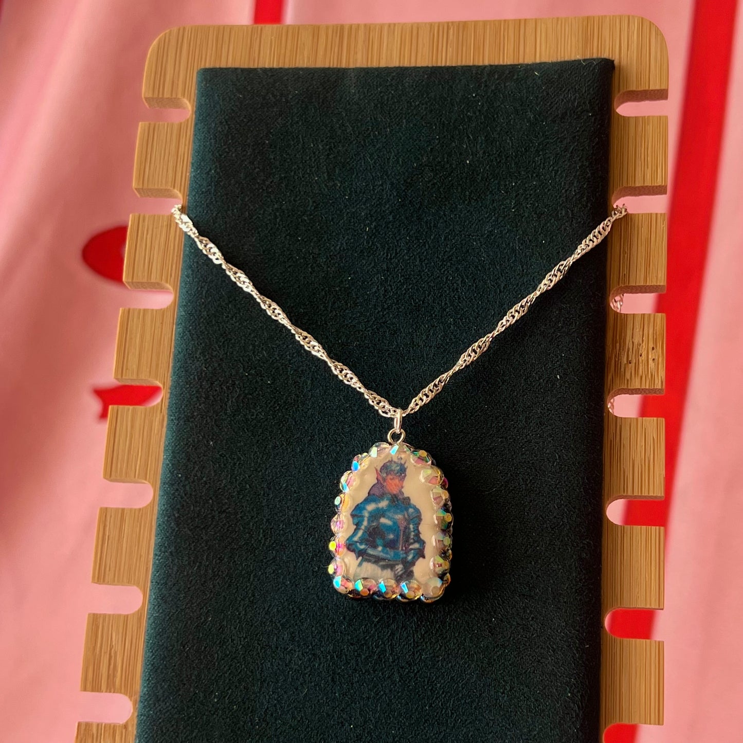 Elf Knight Necklace by Olive Made — a handmade polymer clay fantasy charm necklace featuring a medieval-inspired elf in knight armor, embellished with iridescent pearls and sparkling rhinestones. This whimsical medievalcore / fairycore statement piece comes on a 20” 925 sterling silver chain and arrives gift-ready in a Victorian patterned box with a green bow. Perfect for renaissance fair outfits, elfcore styling, and storybook gifting. Ready to ship in 1–3 business days.