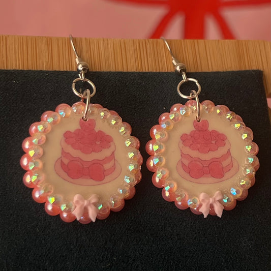 Alt text: Handcrafted polymer‑clay jelly cake earrings with pink coquette bows, iridescent pearls and rhinestones – a sweet, pastel kawaii accessory perfect for a cute dangle look.