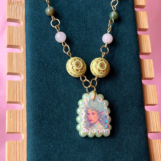 Fairycore crystal portrait necklace — 20" beaded necklace with rose quartz, Indian agate, and upcycled rutilated quartz plus handmade iridescent bedazzled portrait charm. 18k gold plated findings + 18k gold filled jump rings; ornate toggle clasp. Gift-ready green Victorian-style box; ready to ship.
