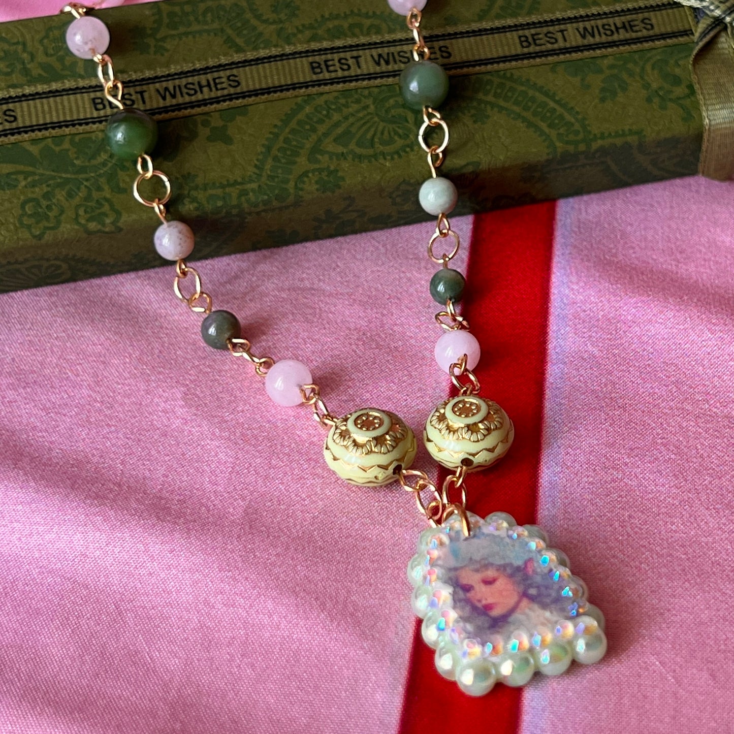Fairycore crystal portrait necklace — 20" beaded necklace with rose quartz, Indian agate, and upcycled rutilated quartz plus handmade iridescent bedazzled portrait charm. 18k gold plated findings + 18k gold filled jump rings; ornate toggle clasp. Gift-ready green Victorian-style box; ready to ship.