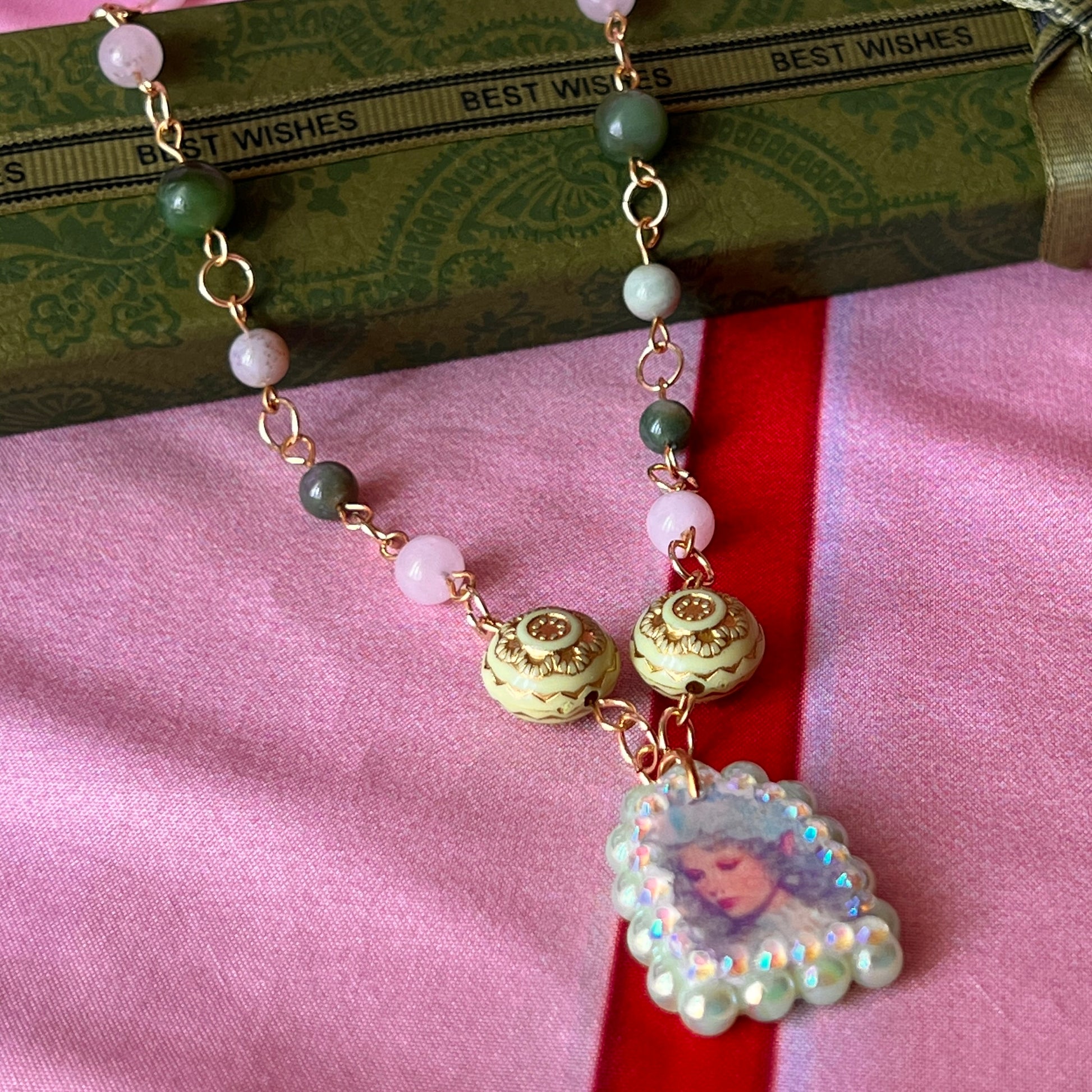 Fairycore crystal portrait necklace — 20" beaded necklace with rose quartz, Indian agate, and upcycled rutilated quartz plus handmade iridescent bedazzled portrait charm. 18k gold plated findings + 18k gold filled jump rings; ornate toggle clasp. Gift-ready green Victorian-style box; ready to ship.