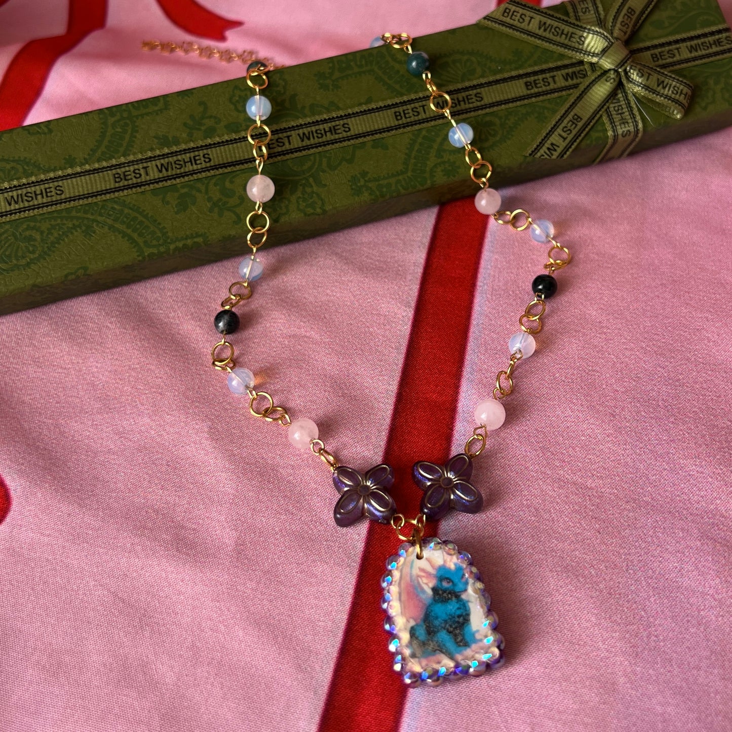 Gold plated dragon charm necklace — one-of-a-kind beaded necklace with rose quartz, opalite, and Indian agate plus handmade iridescent polymer clay dragon charm bedazzled with iridescent pearls, dark purple pearls, and rhinestones. 18k gold-plated links; 20" length + 2" star extender. Ready to ship.