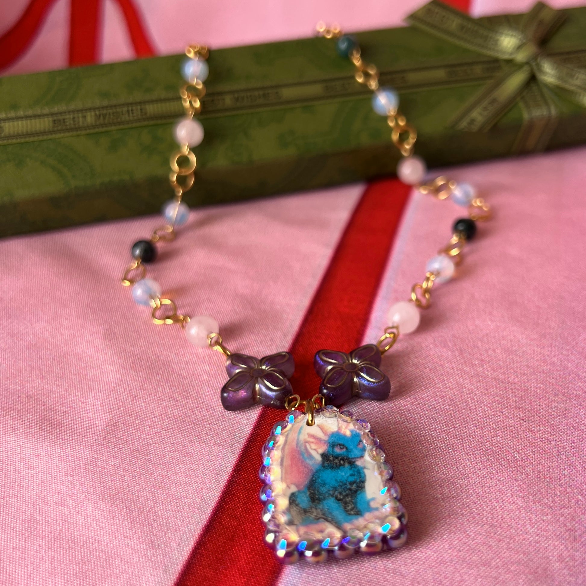 Gold plated dragon charm necklace — one-of-a-kind beaded necklace with rose quartz, opalite, and Indian agate plus handmade iridescent polymer clay dragon charm bedazzled with iridescent pearls, dark purple pearls, and rhinestones. 18k gold-plated links; 20" length + 2" star extender. Ready to ship.