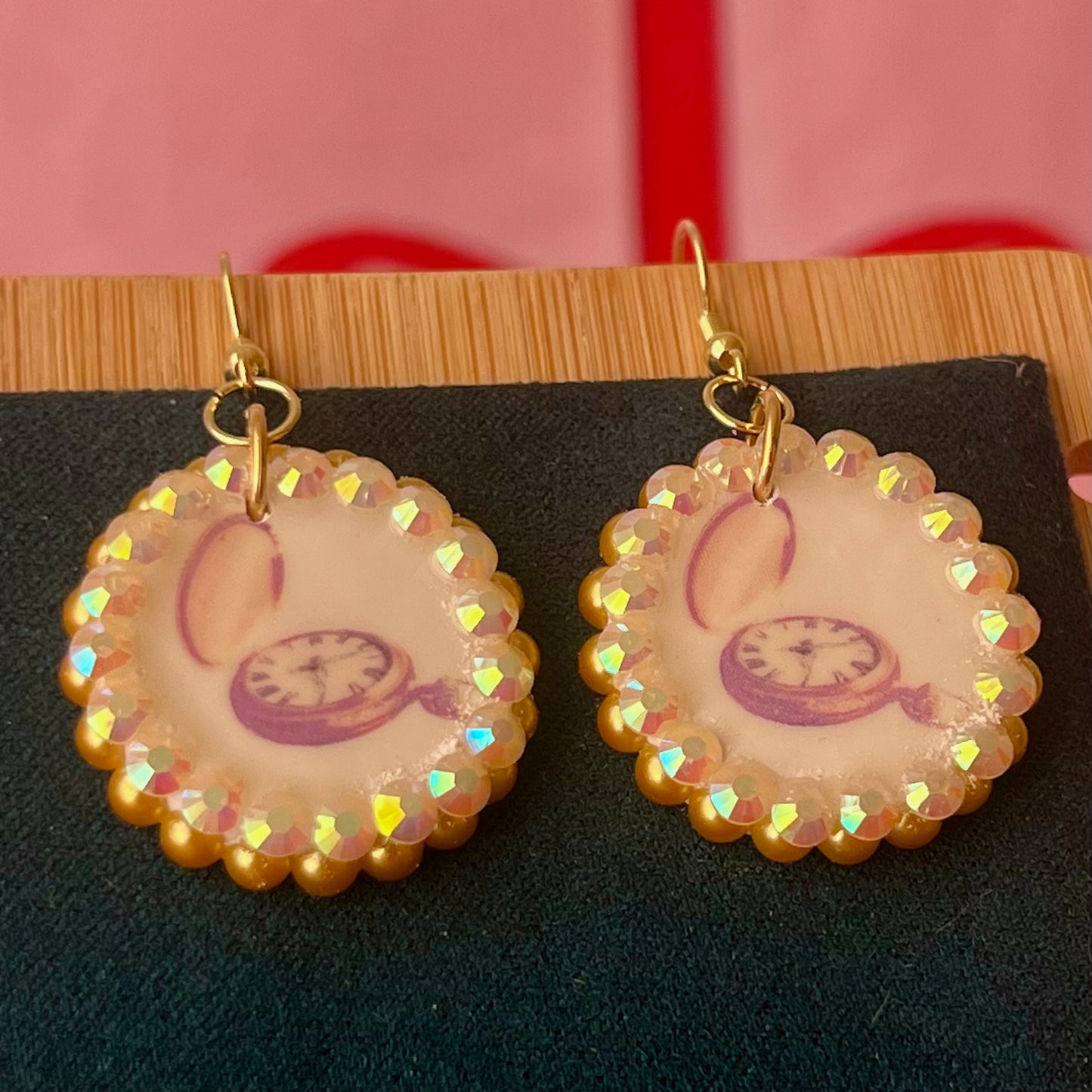 Handmade golden compass charm earrings featuring polymer‑clay image transfer, a 1‑inch circle charm framed with golden pearls and rhinestones, 18k gold‑plated hypoallergenic findings, and a balanced, luxuriously weighted feel—perfect nautical‑core, travel‑talisman, gold statement jewelry for a meaningful, sparkly look.