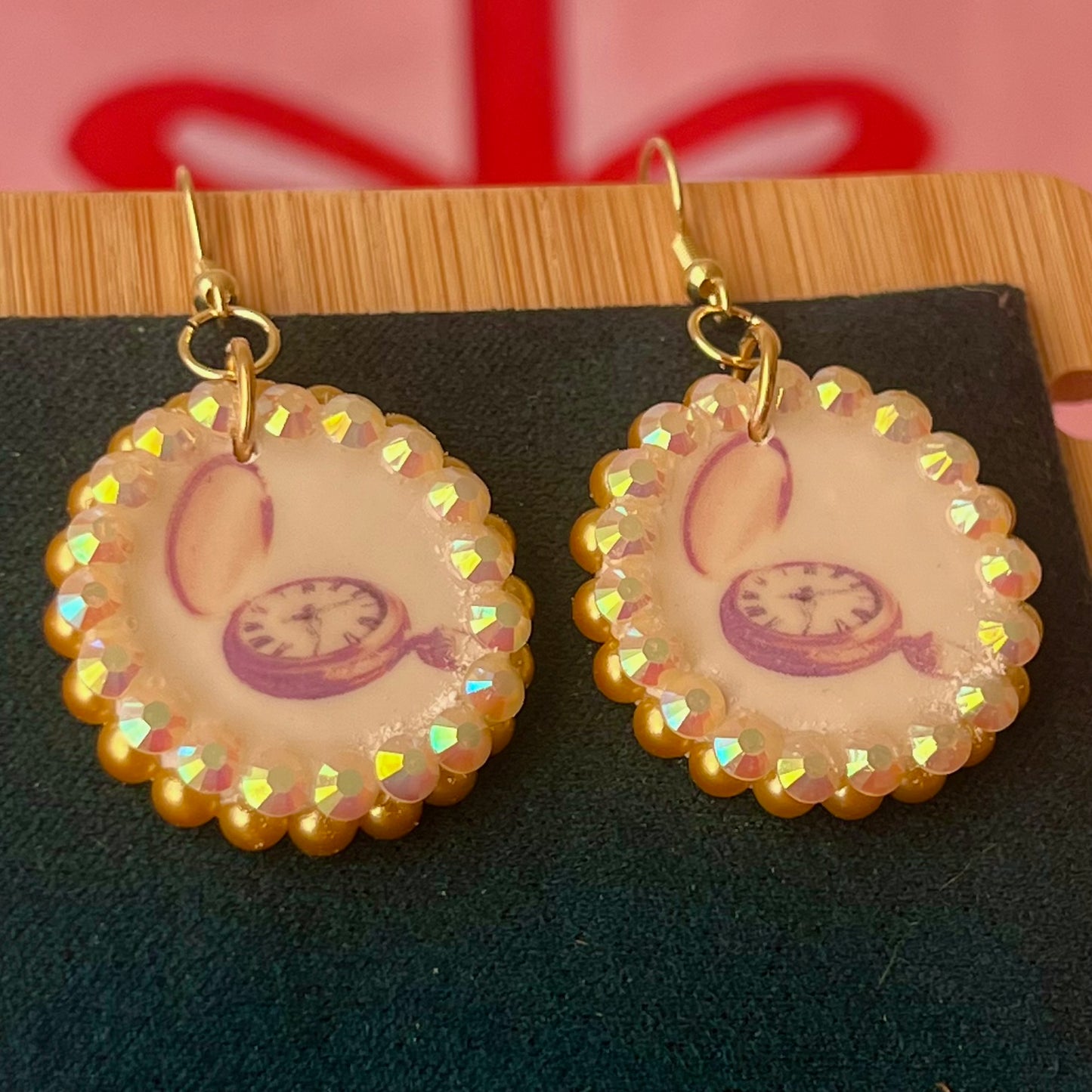 Handmade golden compass charm earrings featuring polymer‑clay image transfer, a 1‑inch circle charm framed with golden pearls and rhinestones, 18k gold‑plated hypoallergenic findings, and a balanced, luxuriously weighted feel—perfect nautical‑core, travel‑talisman, gold statement jewelry for a meaningful, sparkly look.