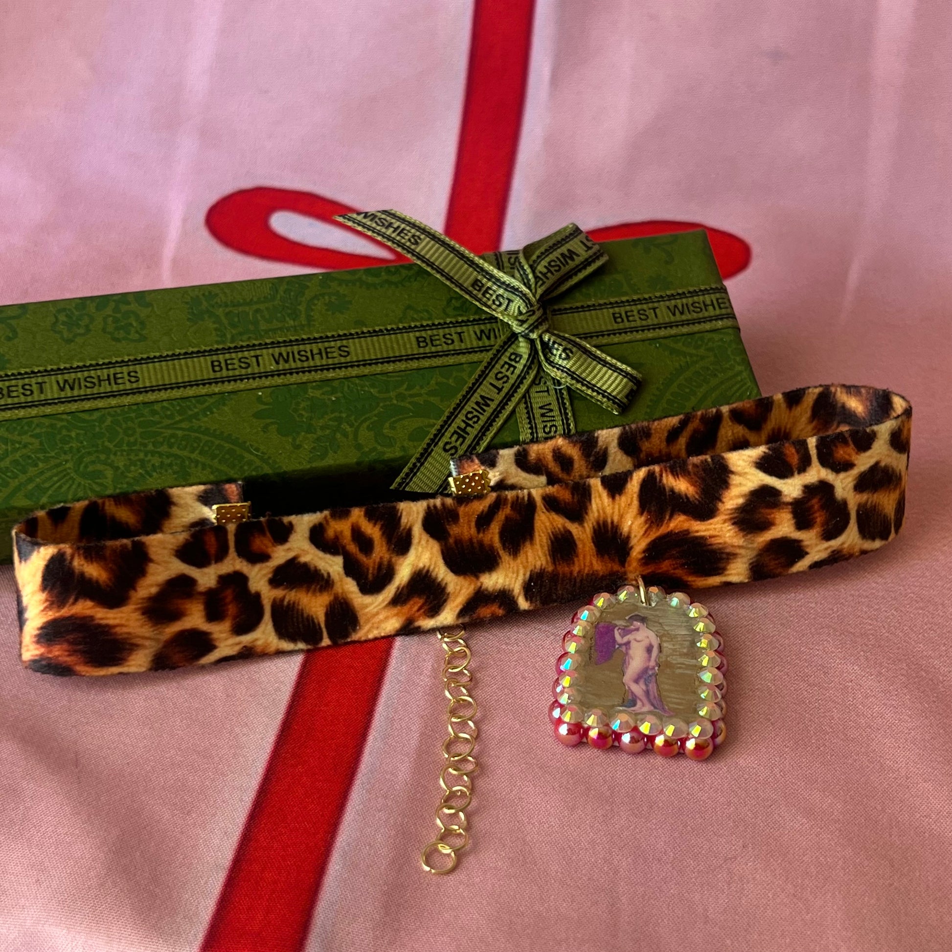 High Jungle Priestess choker — soft cheetah print choker with handmade polymer clay charm featuring neoclassical painting element, framed with bright red pearls. Adjustable fit ~14–16" with extension chain. Gift-ready green Victorian-patterned box + bow. Ready to ship in 1–3 days.