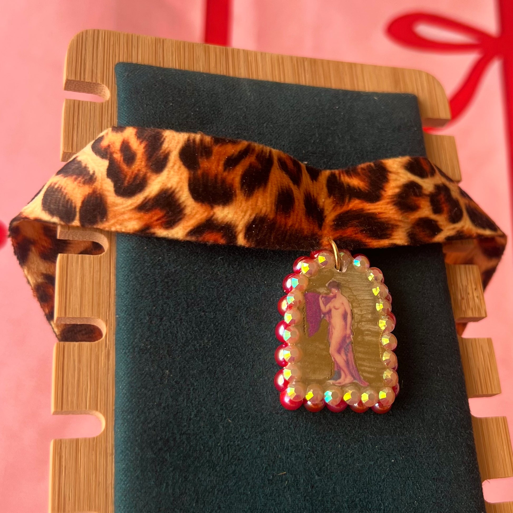 High Jungle Priestess choker — soft cheetah print choker with handmade polymer clay charm featuring neoclassical painting element, framed with bright red pearls. Adjustable fit ~14–16" with extension chain. Gift-ready green Victorian-patterned box + bow. Ready to ship in 1–3 days.