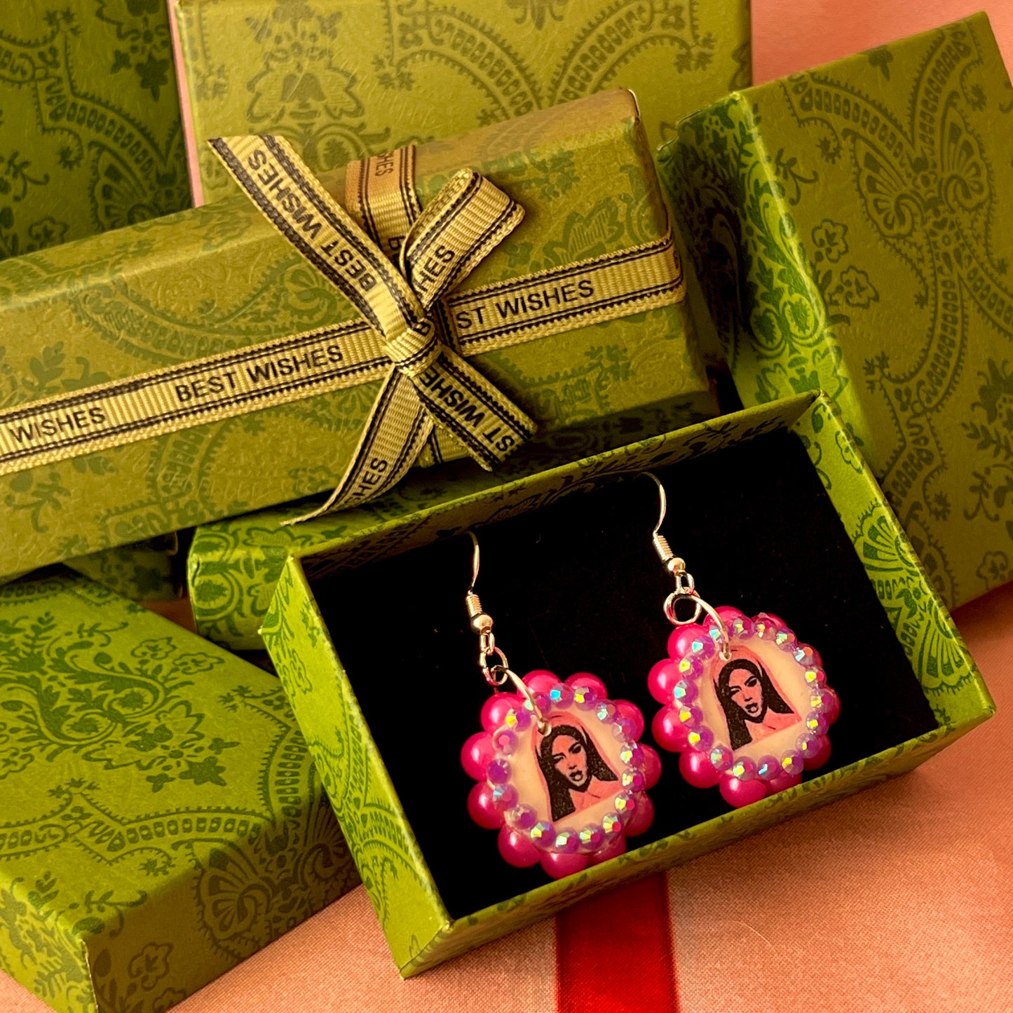 Alt text: Hot pink Y2K nun earrings featuring handmade polymer clay charms bedazzled with iridescent beads, silver plated hypoallergenic hooks, and whimsical gothic, grunge, punk, pink, Y2K style—perfect gift‑ready earrings in a cute green Victorian‑patterned box.