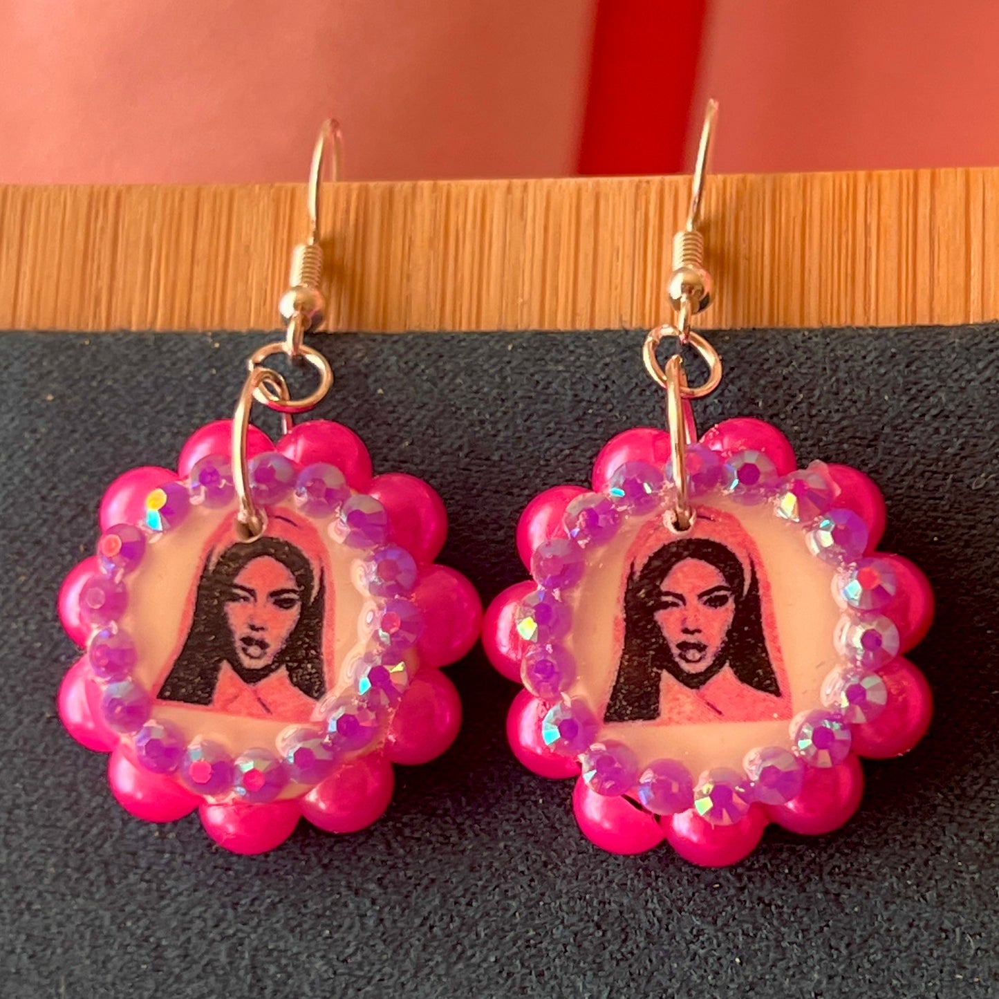 Alt text: Hot pink Y2K nun earrings featuring handmade polymer clay charms bedazzled with iridescent beads, silver plated hypoallergenic hooks, and whimsical gothic, grunge, punk, pink, Y2K style—perfect gift‑ready earrings in a cute green Victorian‑patterned box.